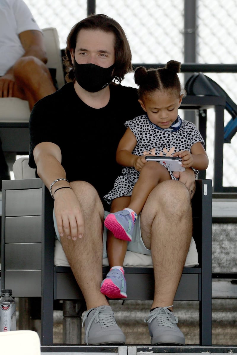 Serena Williams' husband and daughter, Alexis Ohanian and Alexis Olympia Ohanian, watch the action. AFP