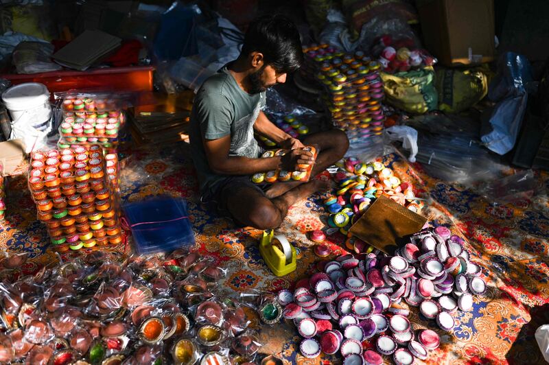 A potter sells earthen lamps in New Delhi. AFP