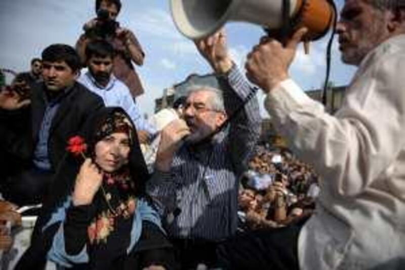 Defeated Iranian presidential candidate Mir Hossein Mousavi (C) addresses supporters as he attends a rally with his wife Zahra Rahnavard in Tehran on June 15, 2009. Opposition supporters defied a ban to stage a mass rally in Tehran in protest at President Mahmoud Ahmadinejad's landslide election win, as Iran faced a growing international backlash over the validity of the election and the subsequent crackdown on opposition protests. AFP PHOTO/OLIVIER LABAN-MATTEI *** Local Caption ***  190407-01-08.jpg