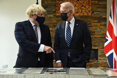 Britain's Prime Minister Boris Johnson (L) and US President Joe Biden, both wearing face coverings due to Covid-19, view a display ahead of their a bi-lateral meeting at Carbis Bay, Cornwall on June 10, 2021, ahead of the three-day G7 summit being held from 11-13 June.  G7 leaders from Canada, France, Germany, Italy, Japan, the UK and the United States meet this weekend for the first time in nearly two years, for the three-day talks in Carbis Bay, Cornwall. - 
 / AFP / Brendan Smialowski
