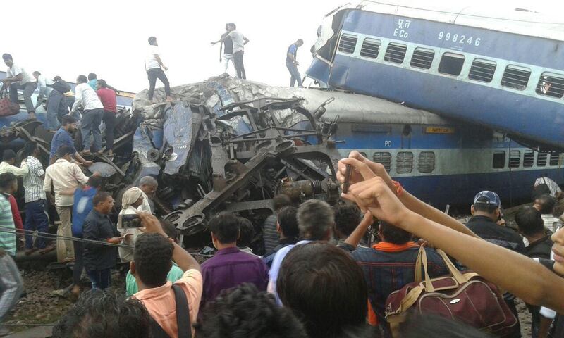 Railway police and local volunteers look for survivors in the upturned coaches of the Kalinga-Utkal Express. The Associated Press