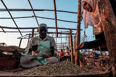 A woman inspects green coffee beans at a stall in the local market in the city of Asosa, Ethiopia. With a new app, coffee drinkers can know more about what's in their cup and how it got there. AFP