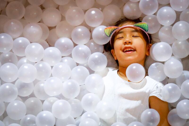 A young girl is covered in plastic balls at a shopping mall in Bangkok, Thailand. EPA