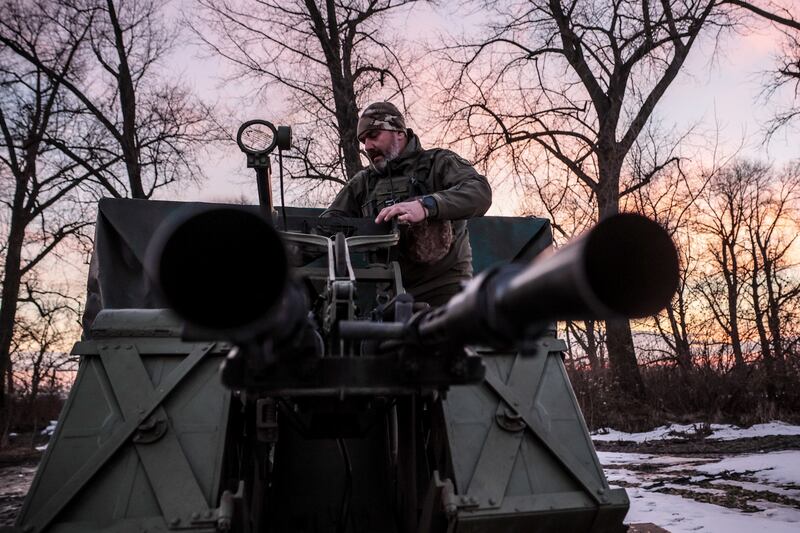A Ukrainian serviceman operates an anti-aircraft machine gun after an air raid alarm in the Kyiv region. EPA