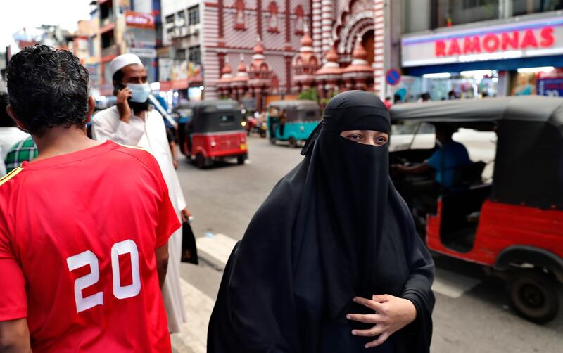 A burqa clad Sri Lankan Muslim woman walks in a street of Colombo, Sri Lanka, Saturday, March 13, 2021. Sri Lanka on Saturday announced plans to ban the wearing of burqas and said it would close more than 1,000 Islamic schools known as madrassas, citing national security. (AP Photo/Eranga Jayawardena)
