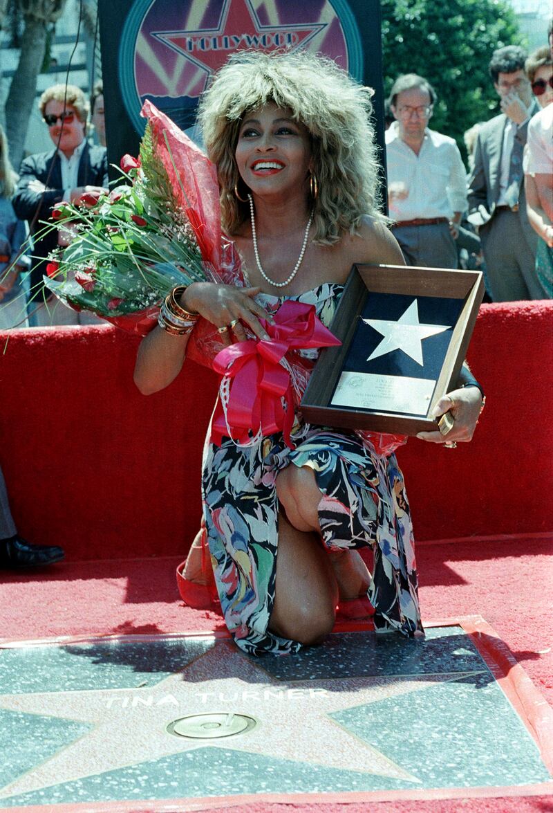 Turner poses with her plaque and a bouquet of roses near her star on the Hollywood Walk of Fame. AP