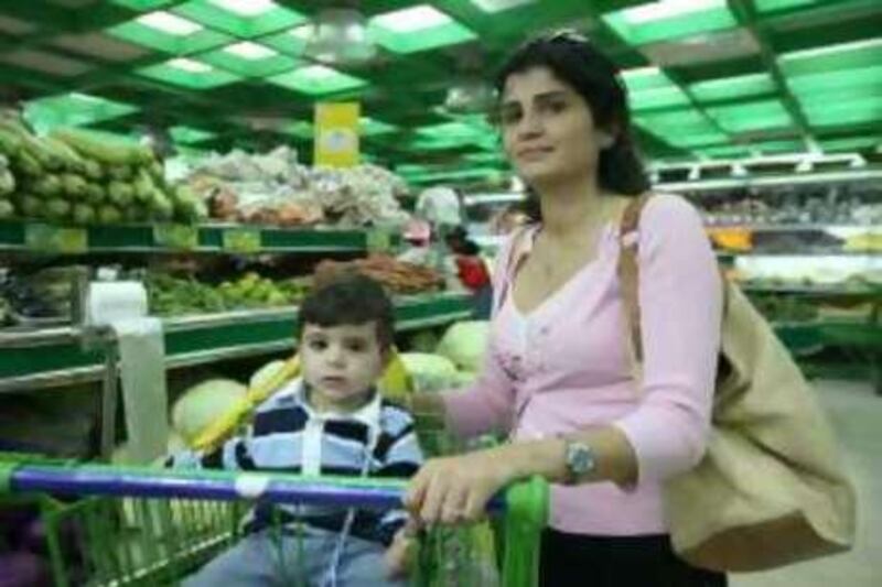 ABU DHABI, UNITED ARAB EMIRATES, 6 November 2008:  Ministry of Economy officails have asked retail giants to cut the prices of staple foods and some goods. Picture of the shoper Alissar Jamil with her son Abdullah. Fatima Al Mutawa/ The National  *** Local Caption ***  FM008-market.JPG