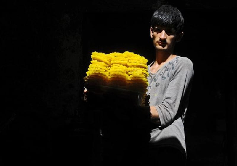An Afghan worker carries sweets at a traditional 'jelabi' (sweet) factory ahead of the Islamic holy month of Ramadan in Herat on July 8, 2013. Throughout the month, devout Muslims must abstain from food and drink from dawn until sunset when they break the fast with the Iftar meal. Traditionally, dates are known as the food the prophet Mohammad ate when he broke from his fast. AFP PHOTO / Aref KARIMI

