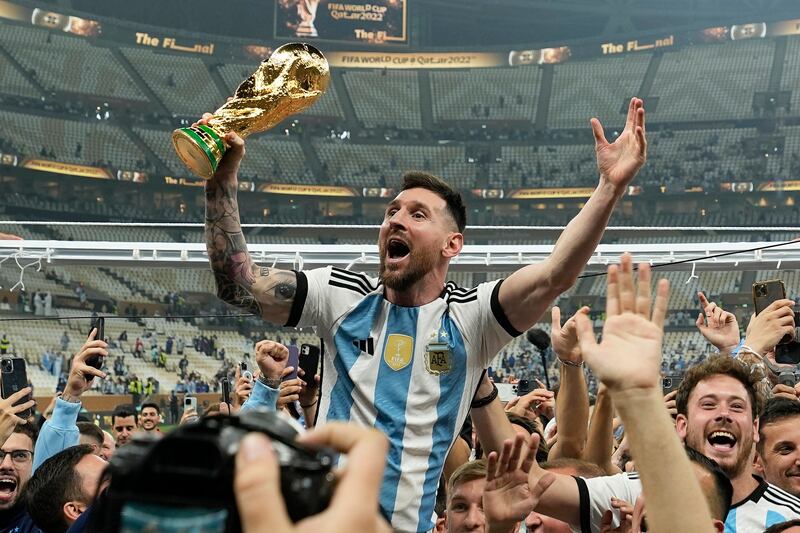 FILE - Argentina's Lionel Messi celebrates with the trophy in front of the fans after winning the World Cup final soccer match between Argentina and France at the Lusail Stadium in Lusail, Qatar, Sunday, Dec.  18, 2022.  Lionel Messi has been named FIFA’s best men’s player after moving to Inter Miami and leading the team to a little-known Leagues Cup title, all while single-handedly elevating soccer’s relevance in the United States.  The 36-year-old Argentina star on Monday was selected over Kylian Mbappe and Erling Haaland — the same pair he beat for his eighth Ballon d’Or award last October.  (AP Photo / Martin Meissner, File)