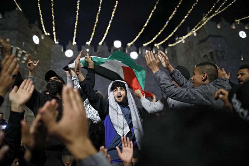 Palestinian protesters wave the national flag outside the Damascus Gate in Jerusalem's Old City on April 26, 2021. AFP