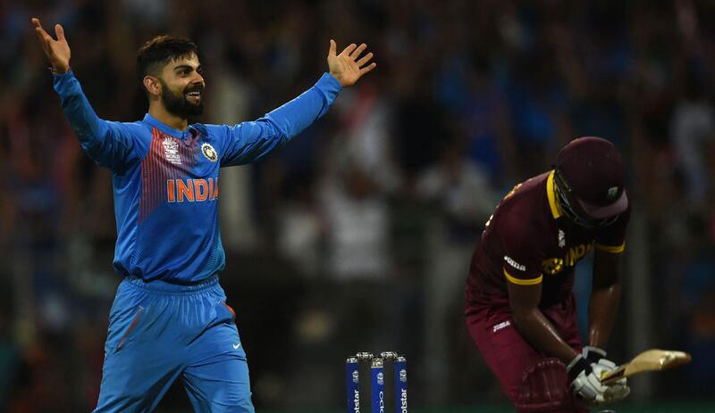 Virat Kohli celebrates after taking the wicket of West Indies' Johnson Charles during their T20 World Cup semi-final at the Wankhede Stadium in Mumbai on March 31, 2016. AFP