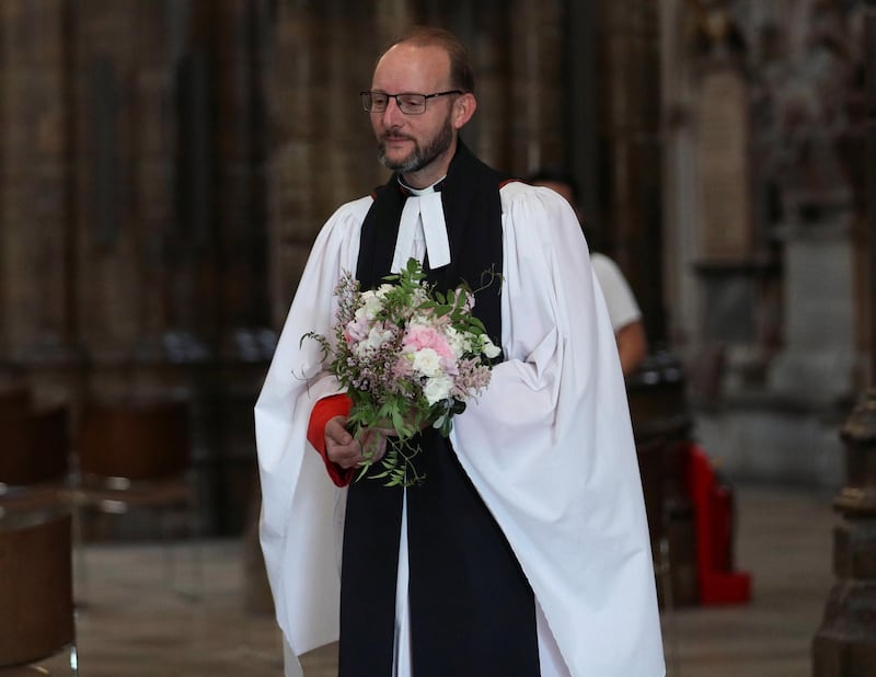 Reverend Anthony Ball, Canon of Westminster, carries Britain's Princess Beatrice's wedding bouquet brought straight from the wedding in Windsor to be traditionally placed on the Tomb of the Unknown Warrior, in Westminster Abbey in London. Reuters