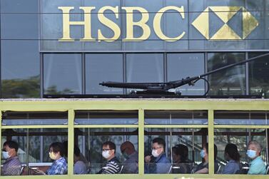 Commuters wearing face masks travel on a tram past HSBC signage displayed outside the bank’s local headquarters in Hong Kong. The bank said its third-quarter pre-tax profits dropped 36%. AFP 
