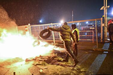 A protester throws a tyre into a fire during a Yellow Vest protest in Le Mans, western France, on December 20, 2018. AFP