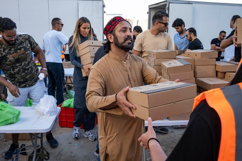 Iftar meals are given to volunteers to pass on to grateful workers. Antonie Robertson / The National