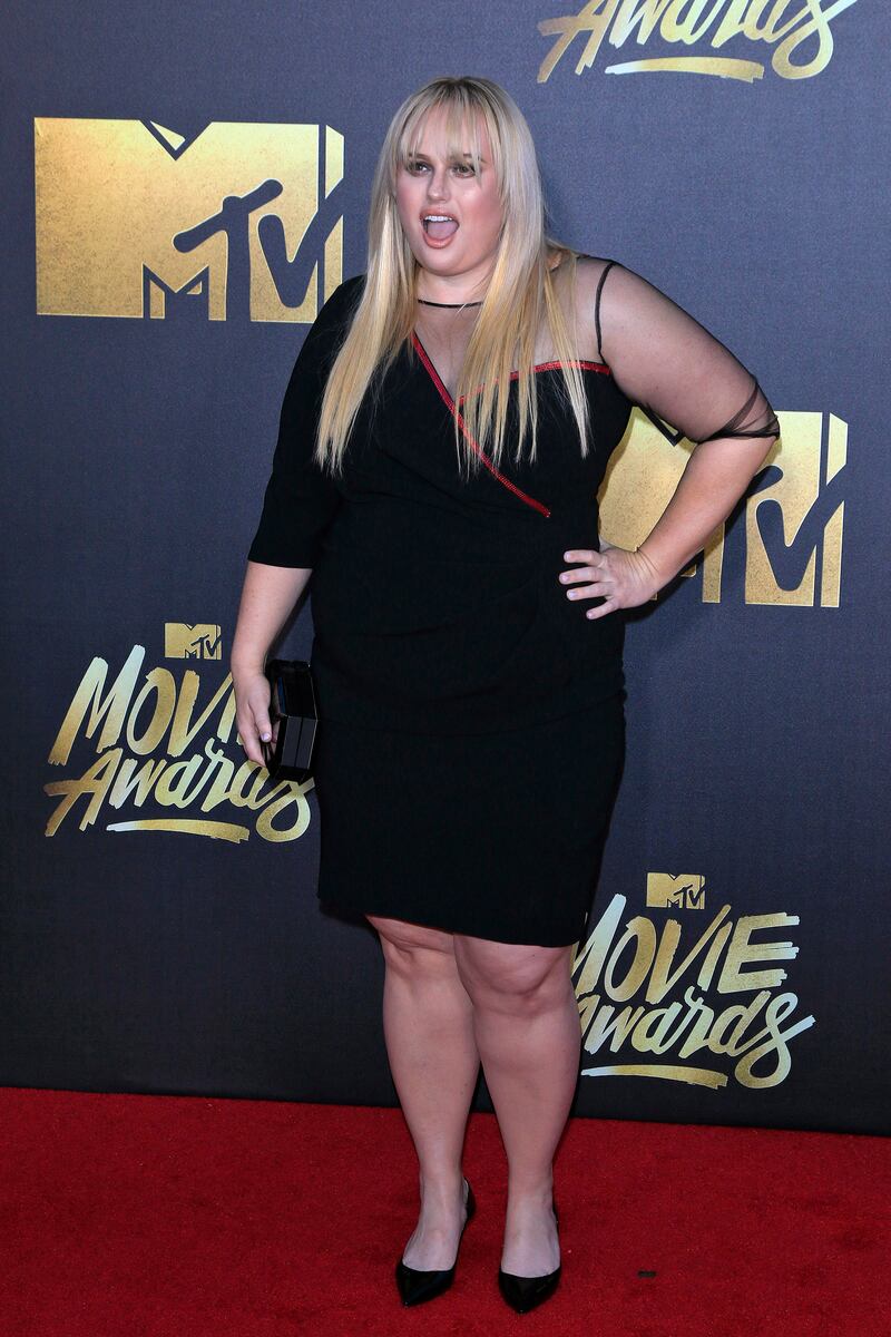 Rebel Wilson, in a black dress with one sheer sleeve, arrives for the MTV Movie Awards in Burbank, California on April 9, 2016. EPA