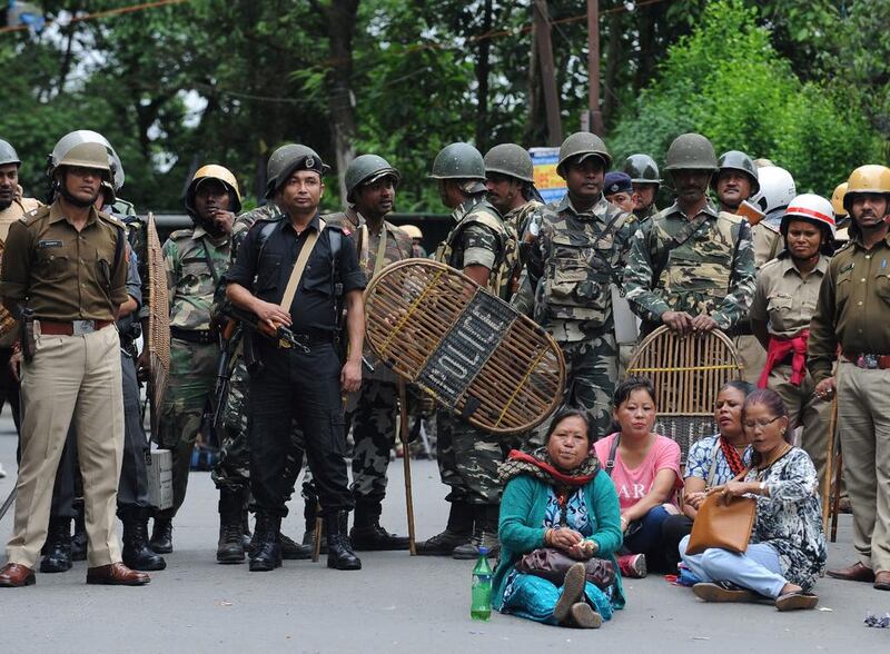 Indian security personnel stand guard during a protest by supporters of the Gorkha Janmukti Morcha (GJM) amid a general strike called by the GJM in Darjeeling. Thousands of tourists fled the Indian hill resort of Darjeeling after local activists demanding the creation of a new Indian state warned that a general strike could degenerate into violence. Hundreds of troops and riot police patrolled the streets of the famed tea-producing resort in eastern India as panicked tourists packed their bags. AFP
