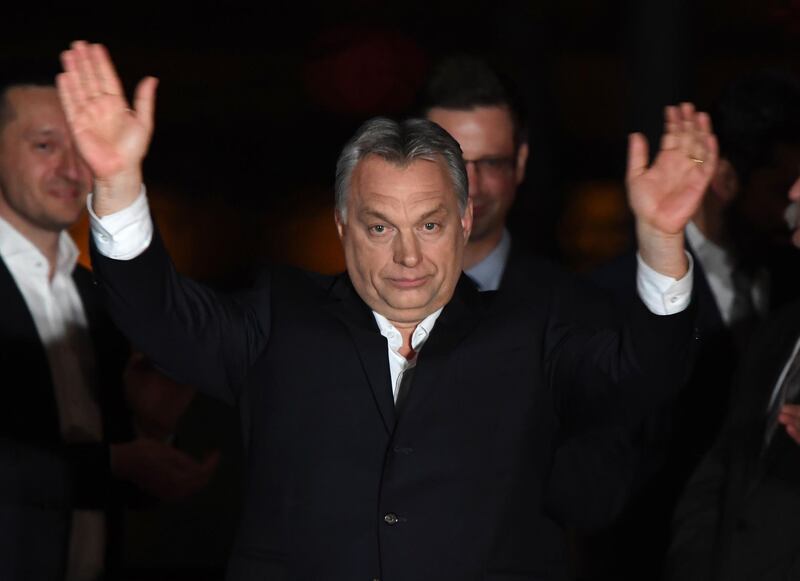TOPSHOT - Hungarian Prime Minister Viktor Orban (C) celebrates on podium on the bank of the Danube River after winning the parliamentary election with members of his FIDESZ party on April 8, 2018 in Budapest. / AFP PHOTO / ATTILA KISBENEDEK