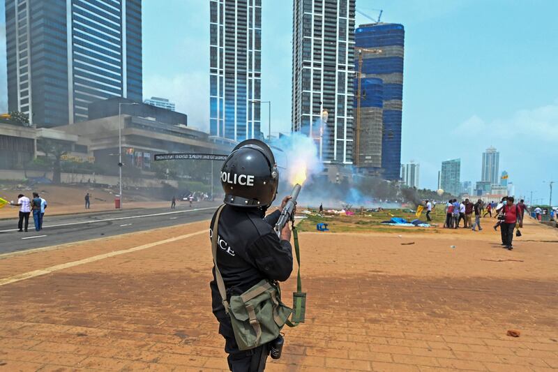 A policeman fires tear gas during a clash. AFP