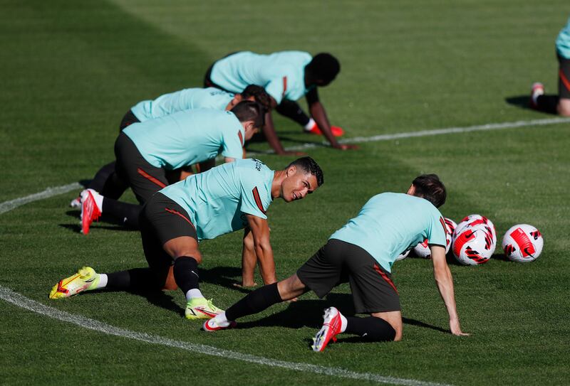 Portugal's Cristiano Ronaldo stretches with teammates during training. Reuters