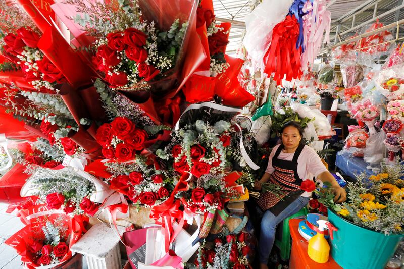 A vendor prepares roses for Valentine's Day at a flower market in Bangkok. EPA
