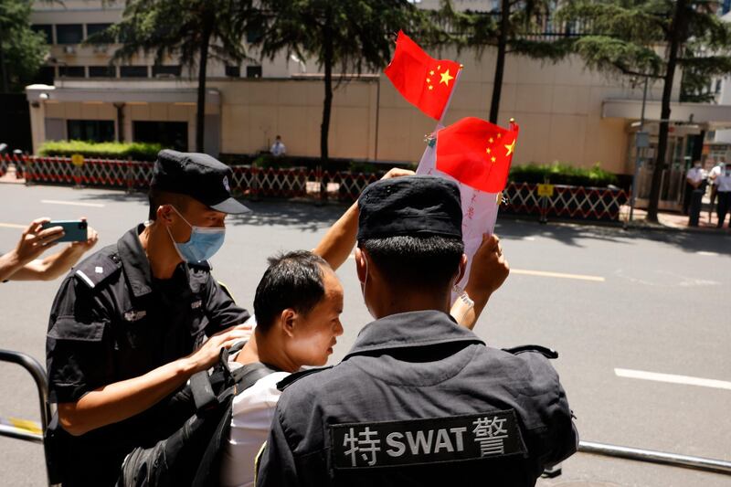 A Chinese man is taken away after shouting pro-China slogans outside the former United States Consulate in Chengdu in southwest China's Sichuan province. Chinese authorities took control of the former U.S. consulate in the southwestern Chinese city of Chengdu on Monday after it was ordered closed amid rising tensions between the global powers. AP Photo