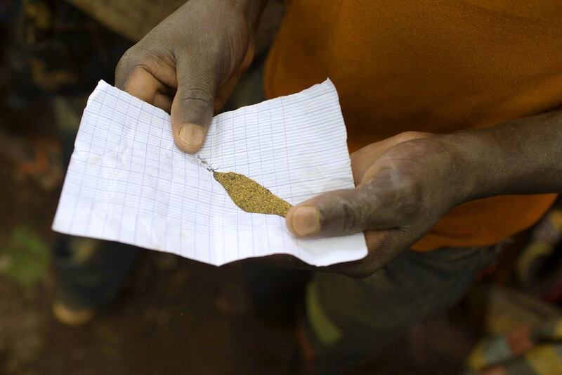 A prospector shows a sample of gold near the open pit at the Ndassima gold mine near Djoubissi. Siegfried Modola / Reuters