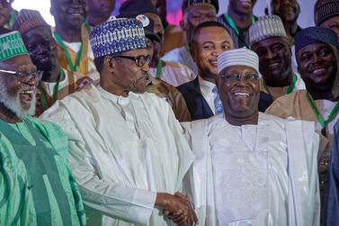 Incumbent President Muhammadu Buhari, centre, shakes hands with opposition presidential candidate Atiku Abubakar after signing an electoral peace accord in Abuja. AP Photo/Ben Curtis