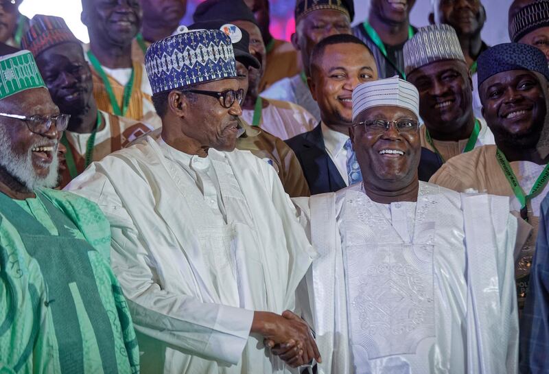 Incumbent President Muhammadu Buhari, left, shakes hands with opposition presidential candidate Atiku Abubakar after signing an electoral peace accord at a conference center in Abuja, Nigeria Wednesday, Feb. 13, 2019. Nigeria is due to hold general elections on Saturday, Feb. 16, 2019. (AP Photo/Ben Curtis)