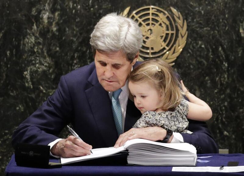 US secretary of state John Kerry holds his granddaughter Isabel Dobbs-Higginson as he signs the Paris Agreement on climate change at the United Nations headquarters in New York on April 22, 2016. Mark Lennihan / AP Photo