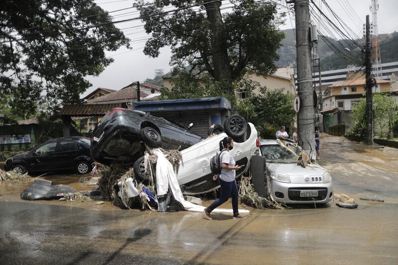 Cars piled up by floodwaters on a street. EPA