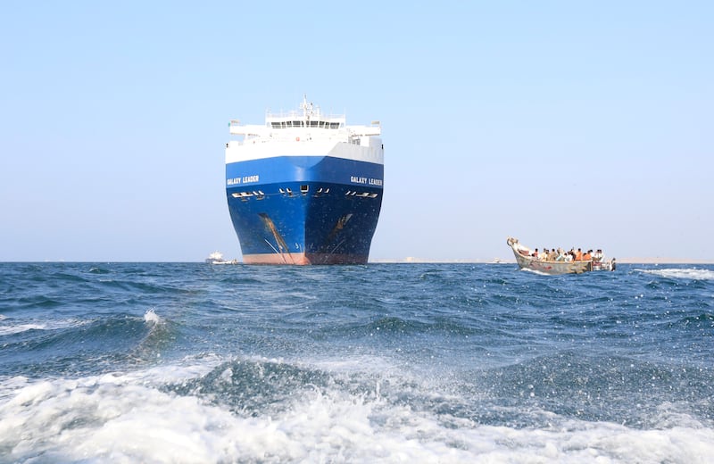 A boat sails past the Galaxy Leader cargo ship, which was seized by Yemen's Iran-backed Houthis rebels in the Red Sea. EPA