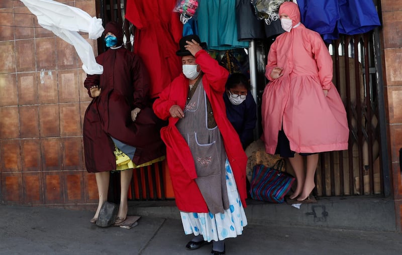 An Aymara woman tries on a frock at a store selling protective clothing suited for the dress style of Bolivian indigenous women from the highlands, amid the new coronavirus pandemic, in La Paz, Bolivia. AP Photo