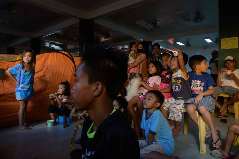 Children displaced by the eruption watch television at an evacuation centre in Santo Tomas. Philippine authorities warm the volcano could be "recharging" for a more powerful explosion. Ed Jones / AFP