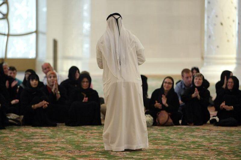 Ahmed al Mehairbi, one of the few Emiratis working in the service sector, conducts a guided tour at the Sheikh Zayed Mosque.