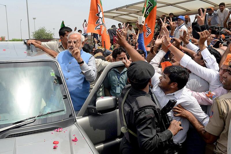Narendra Modi waves as he arrives at Indira Gandhi International Airport in New Delhi. Prakash Singh / AFP