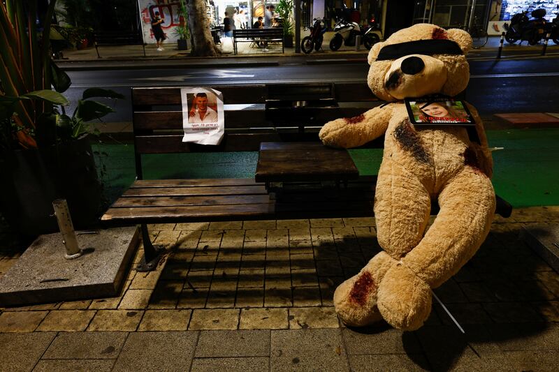 A teddy bear symbolising hostages and missing children is placed on a bench in Tel Aviv, as people gather for a vigil to mark the one-month anniversary of the October 7 attack by Hamas militants on Israel. Reuters