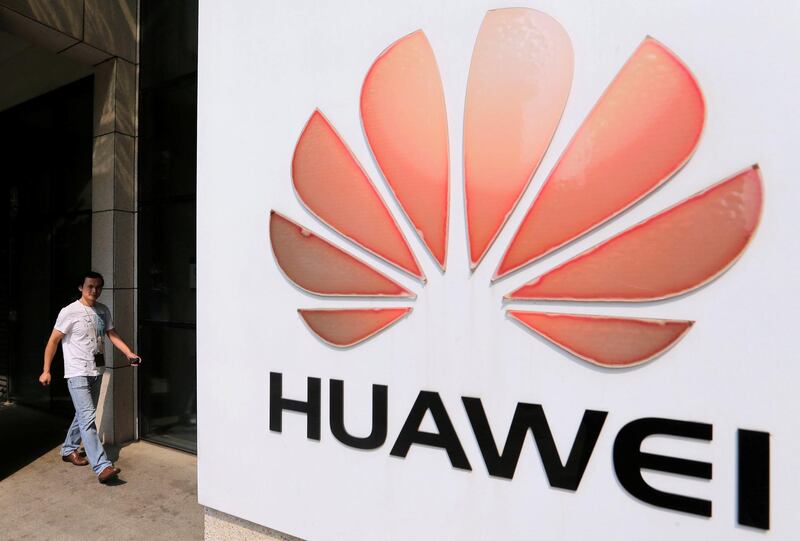 FILE PHOTO:  A man walks past a Huawei company logo outside the entrance of a Huawei office in Wuhan, Hubei province October 9, 2012.  REUTERS/Stringer/File Photo