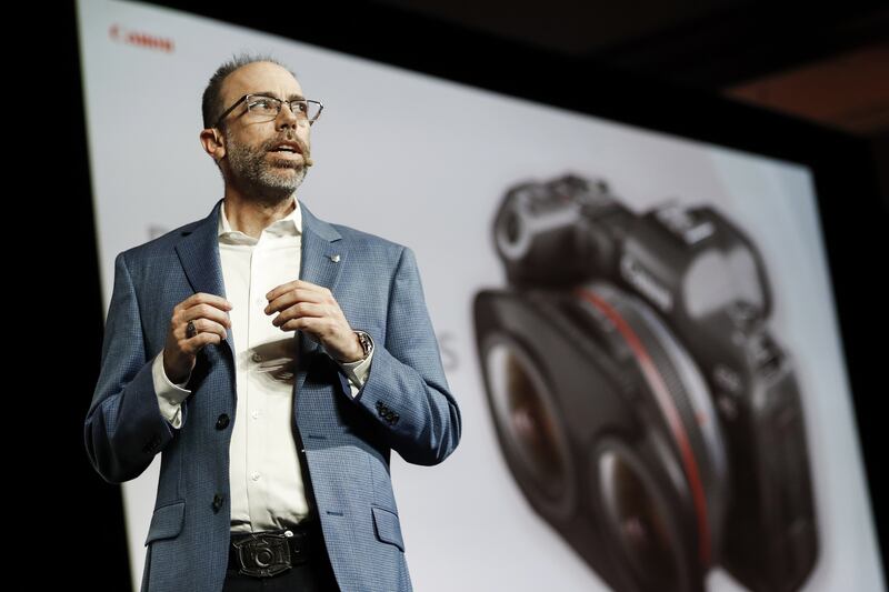 Canon adviser Drew MacCallum unveils the company's dual photo lens before the start of the technology trade show. PA