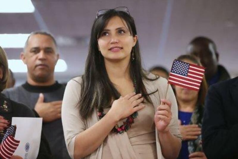 Immigrants listen to the national anthem during a naturalisation ceremony in Newark, New Jersey.