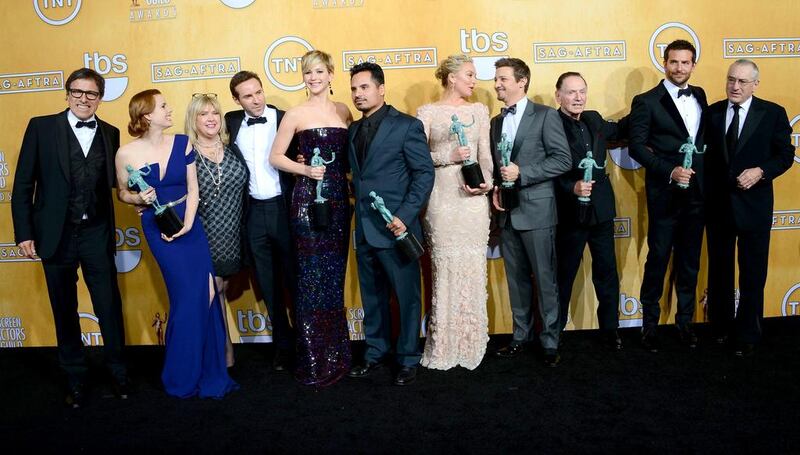 From left, the writer and director David O. Russell with the actors Amy Adams, Colleen Camp, Alessandro Nivola, Jennifer Lawrence, Michael Pena, Elisabeth Rohm, Jeremy Renner, Paul Herman, Bradley Cooper, and Robert De Niro, winners of the Outstanding Performance by a Cast in a Motion Picture award for American Hustle, at the 20th Annual Screen Actors Guild Awards.  Ethan Miller / Getty Images / AFP 
