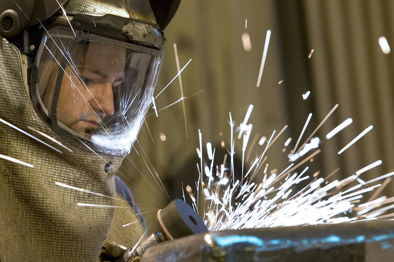A grinder works on a freshly cast piece of steel in the foundry. Oli Scarff / AFP