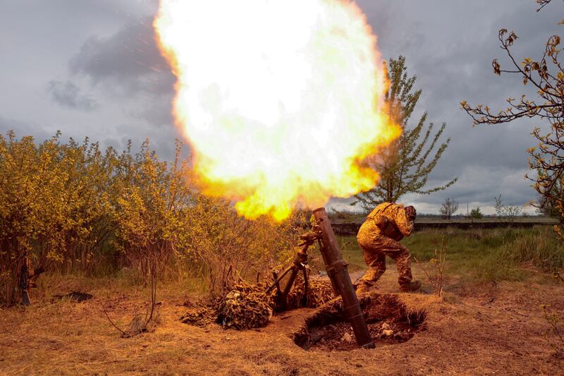 A Ukrainian soldier fires with a mortar, in the Kharkiv region. Reuters