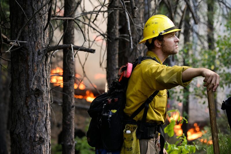 Firefighter Brandon Wenger stands along Highway 120 while monitoring a backburn during the Rim Fire near Yosemite National Park, Calif., on Tuesday, Aug. 27, 2013. Unnaturally long intervals between wildfires and years of drought primed the Sierra Nevada for the explosive conflagration chewing up the rugged landscape on the edge of Yosemite National Park, forestry experts say. The fire had ravaged the largest area in the Sierra's recorded history and one of the largest on record in California. (AP Photo/Jae C. Hong) *** Local Caption ***  Western Wildfire Yosemite.JPEG-046fe.jpg