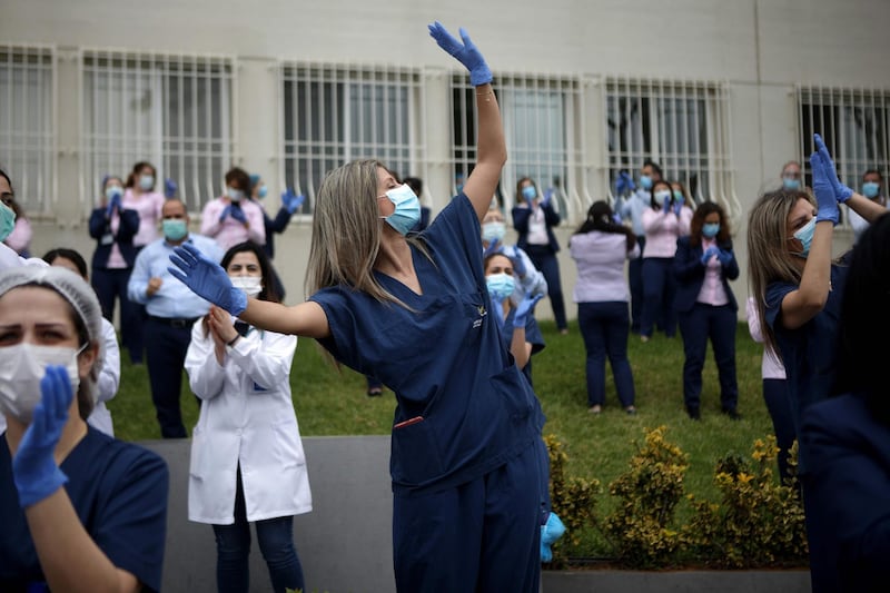CORRECTION / Medical staff members of the Lebanese hospital Notre Dame des Secours dance to music played by a band thanking them for their efforts to support patients during the COVID-19 coronavirus pandemic, in the northern coastal city of Byblos on April 23, 2020.   / AFP / PATRICK BAZ
