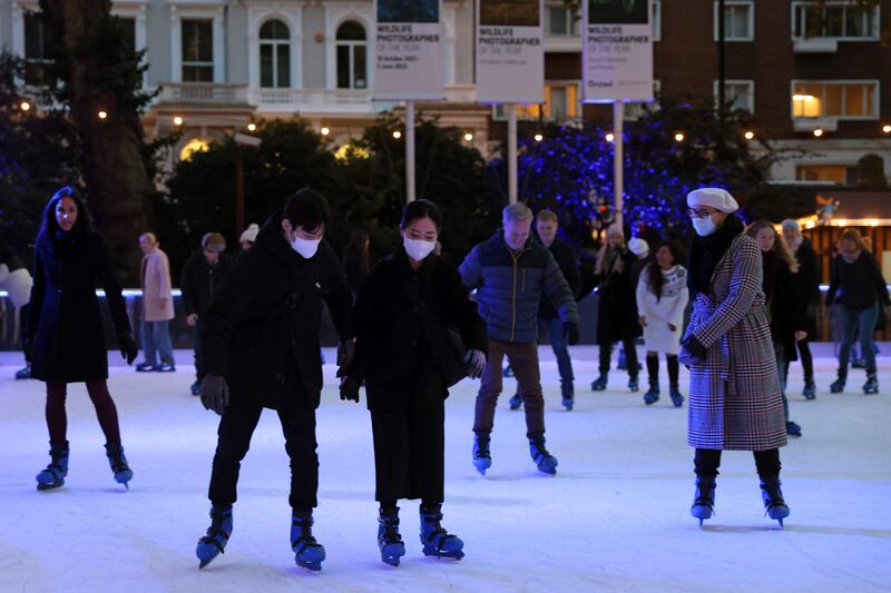 Skaters, most wearing face masks to combat the spread of coronavirus, skate on the ice rink at the Natural History Museum in London. AFP