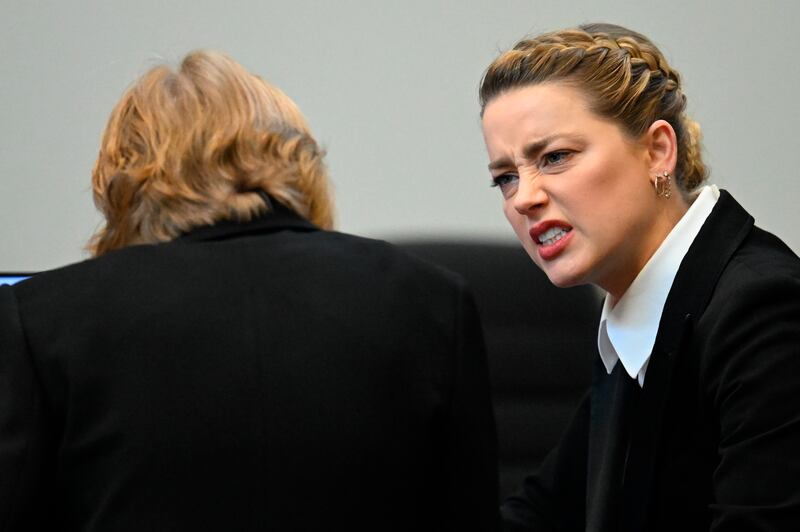 Amber Heard speaks with her lawyer. AP