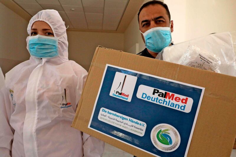 Dr Issam Mujahed, right, a member of the Pal-Med Europe, presents medical donations to doctors battling the coronavirus in Hebron in the occupied West Bank. AFP