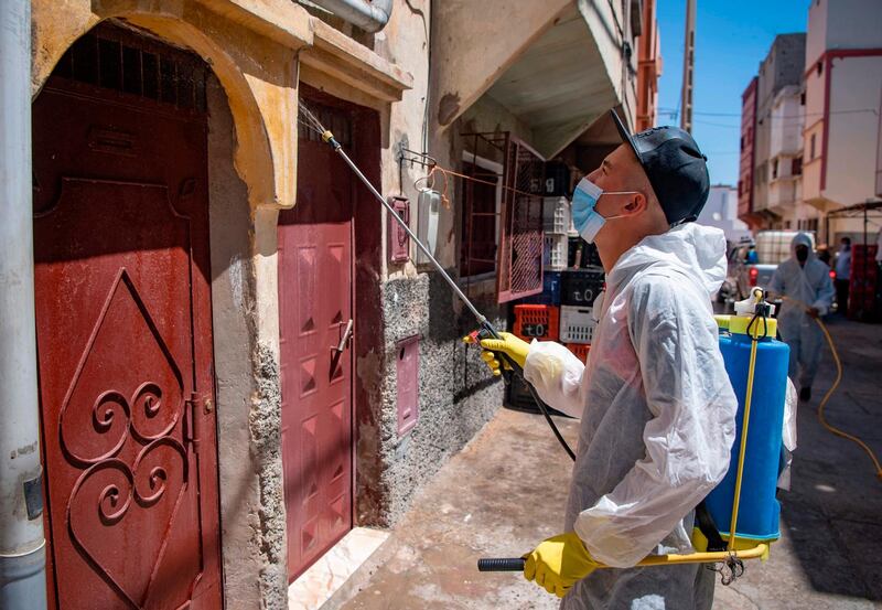 A Moroccan municipal worker disinfects outside a house in a closed street in the southern port city of Safi.  AFP