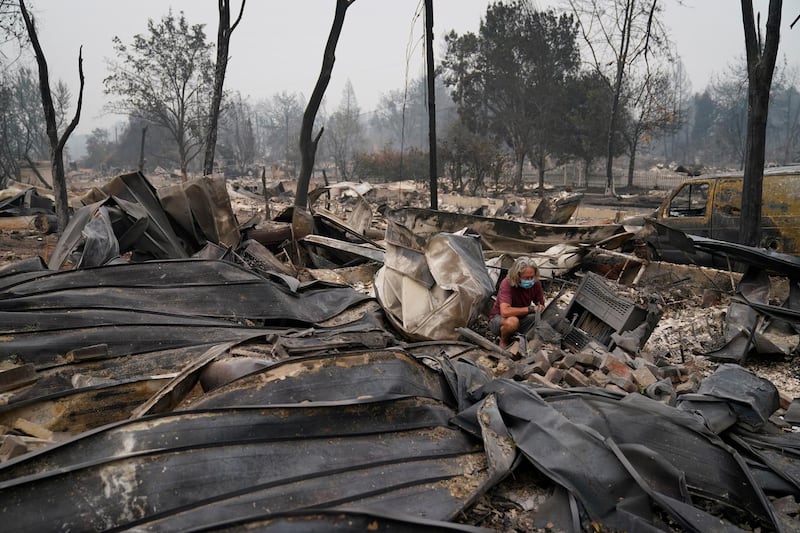 Mark Buktenica looks through the rubble of Eden McCarthy's home, destroyed by the Almeda Fire, in Talent, Oregon. AP Photo